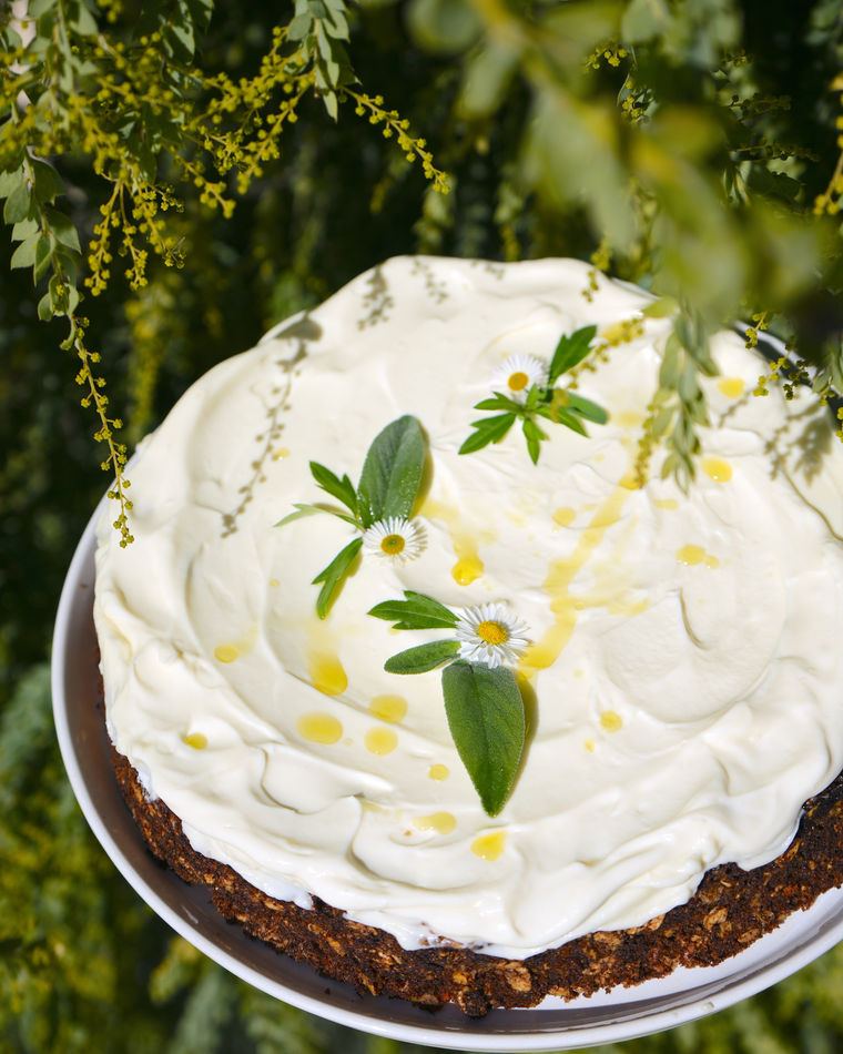 A cake topped with cream and herbs