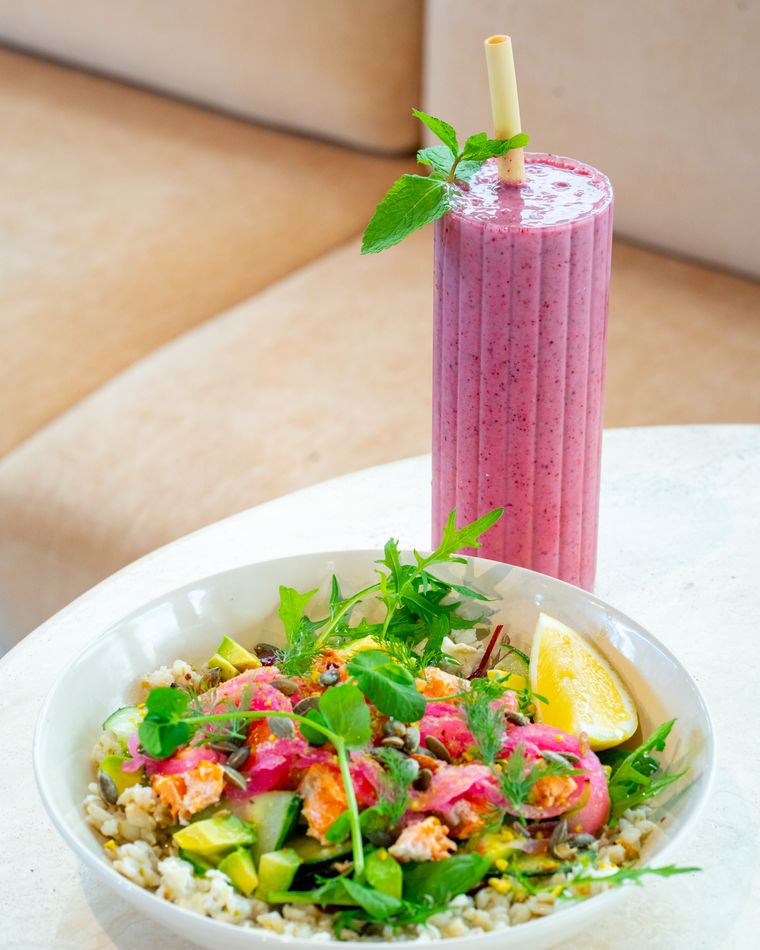 A salad plate beside a smoothie