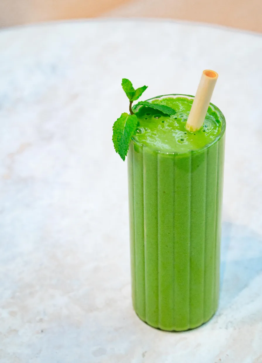 A green smoothie with mint in a ribbed glass