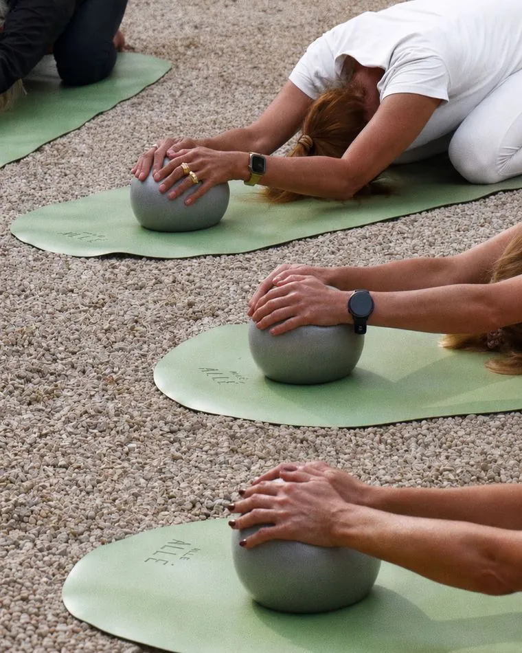 A pilates class on green mats