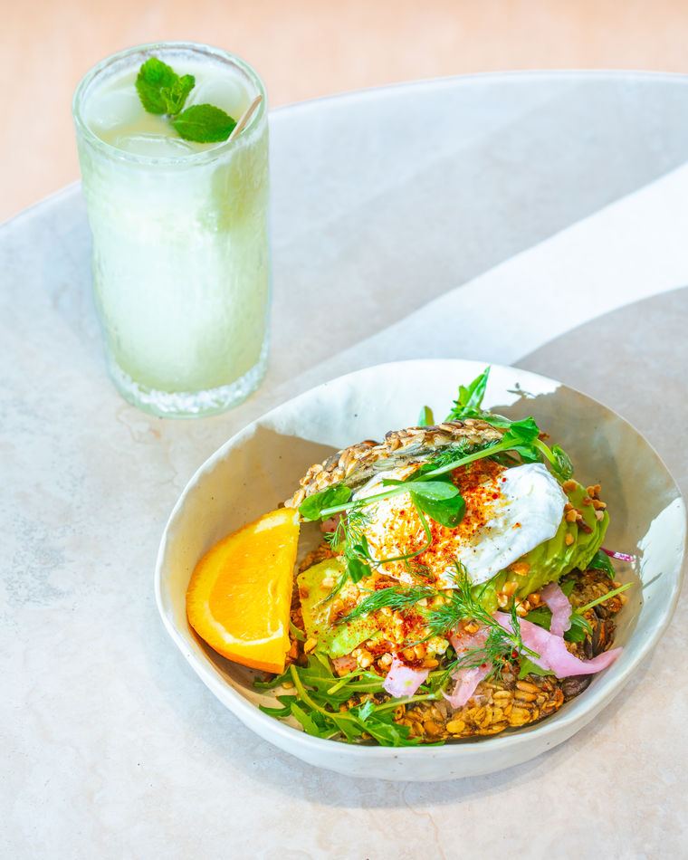 A vibrant grain bowl beside a green drink